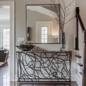 The entrance of this home features a metal console table and a big handcrafted mirror.