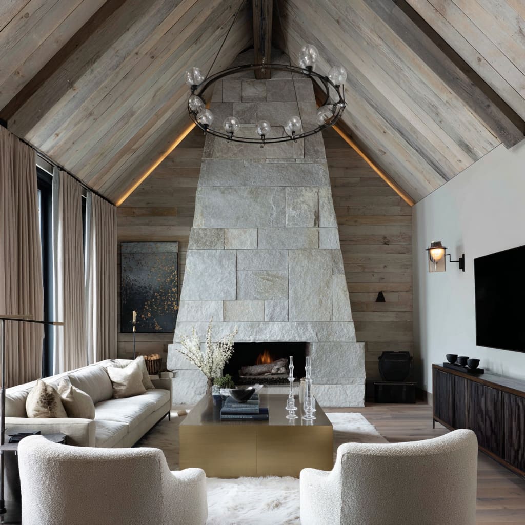 New chalet living room styling featuring tapered stone fireplace, ridge cove lighting, travertine cube table, pebble-gray swivel chairs New chalet living room styling featuring tapered stone fireplace, ridge cove lighting, travertine cube table, pebble-gray swivel chairs
