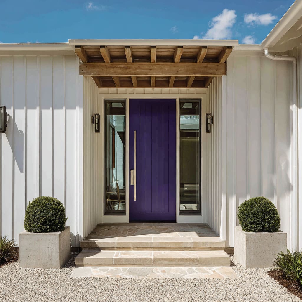 Steel-violet grooved front door with satin pull, white board-and-batten siding, concrete planters Steel-violet grooved front door with satin pull, white board-and-batten siding, concrete planters