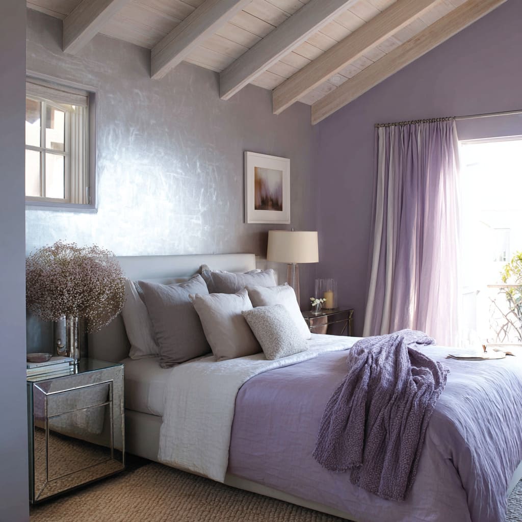 Dormitorio estilo cottage en lavanda suave con acabado metálico en pared, vigas de madera flotante y mesa de noche espejada. Dormitorio estilo cottage en lavanda suave con acabado metálico en pared, vigas de madera flotante y mesa de noche espejada.