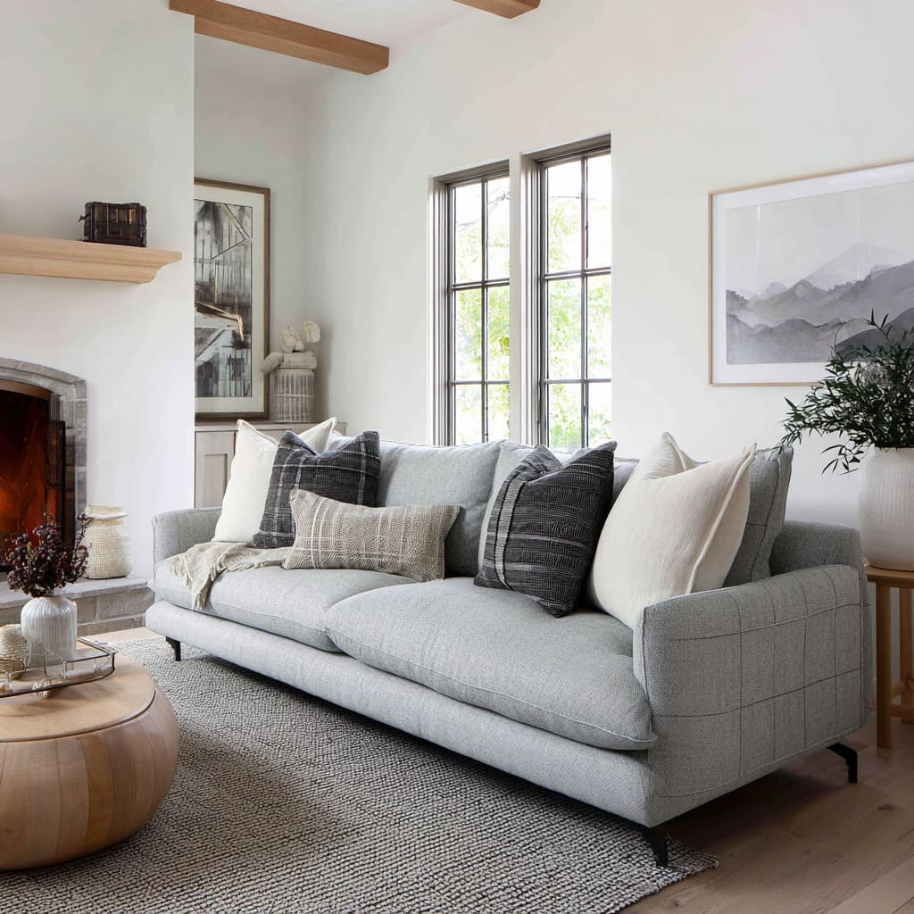 Cool grey seating with off-white cushions, charcoal pillows, and low rectangular pillow