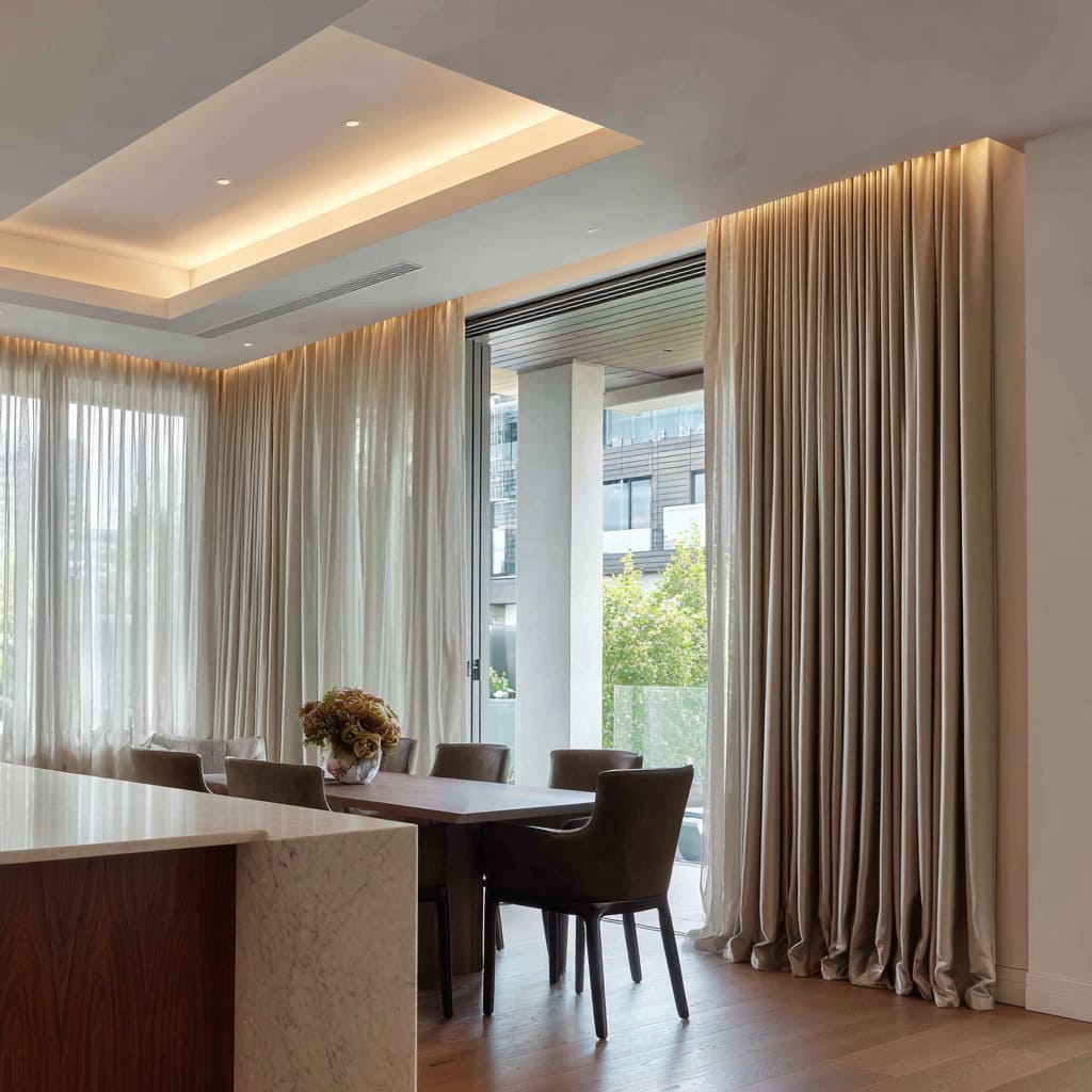 Layered sheer and drapes with warm ceiling glow at slider Layered sheer and drapes with warm ceiling glow at slider