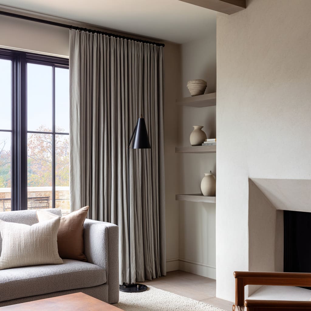 grey drapery with fine pleats balancing design with a black steel window and fireplace niche grey drapery with fine pleats balancing design with a black steel window and fireplace niche