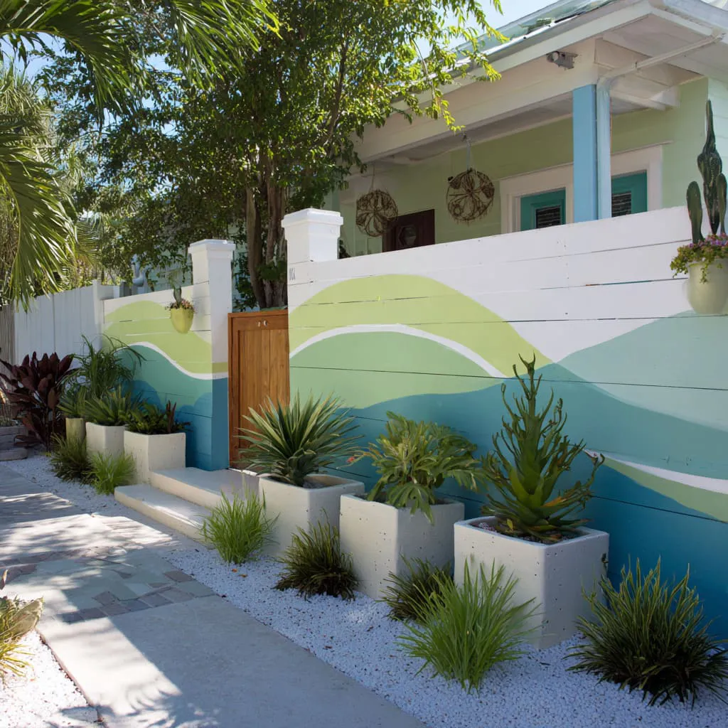 Wavy ribbon paint band that turns a long fence into a landscape scene, then makes the gate feel like it belongs inside the story. Wavy ribbon paint band that turns a long fence into a landscape scene, then makes the gate feel like it belongs inside the story.