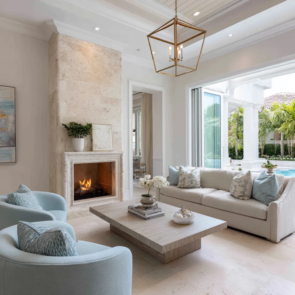 Polished coastal Hamptons living room with a limestone fireplace, brass lantern pendant, white sofa Polished coastal Hamptons living room with a limestone fireplace, brass lantern pendant, white sofa